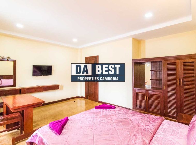 Generous 2 bedroom serviced apartment for rent in Siem Reap Angkor view of master bedroom with working desk, window and pink bedsheets and mirror