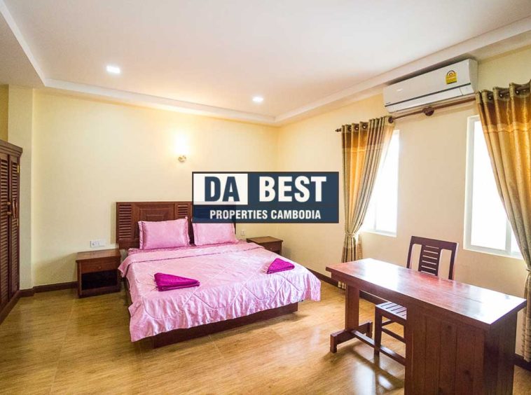 Generous 2 bedroom serviced apartment for rent in Siem Reap Angkor view of master bedroom with working desk, window and pink bedsheets